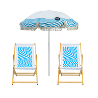 Two wooden deck chairs with blue and white geometric patterns and a matching umbrella with tassels.