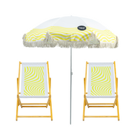 Beach umbrella with yellow and white geometric pattern and two matching wooden deck chairs 